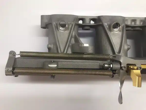 Metal mechanical part with visible springs and levers on a white background.