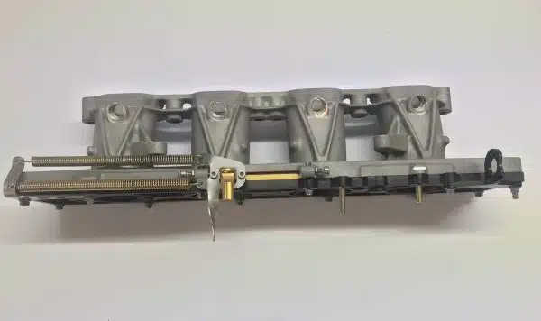 Gray metal model train part with mechanical details on a white background.