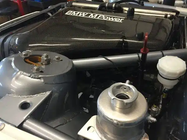 Close-up of a BMW M Power engine bay with various engine components visible.