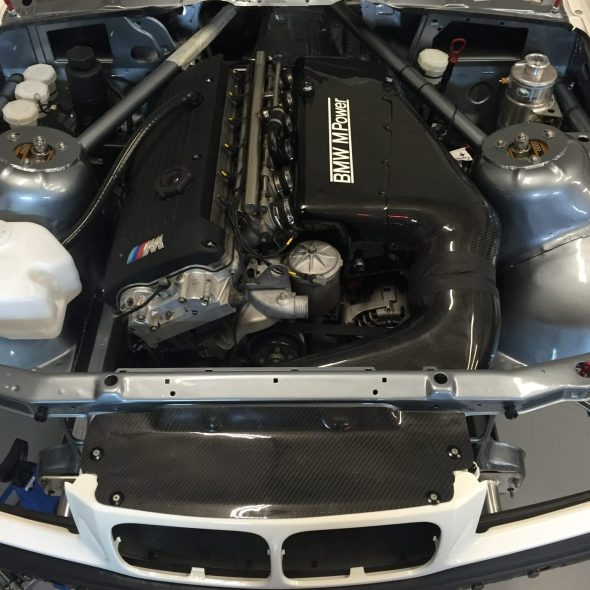 Car hood open showing a clean, modified engine bay with visible components and wiring.