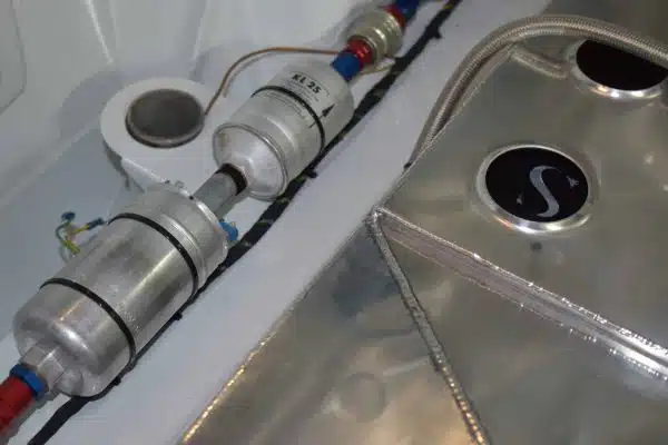 Metal fuel filters and a metal fuel tank with pipes inside a vehicle or machinery compartment.