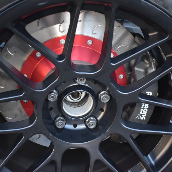 Close-up of a black alloy car wheel with visible brake disc and caliper.
