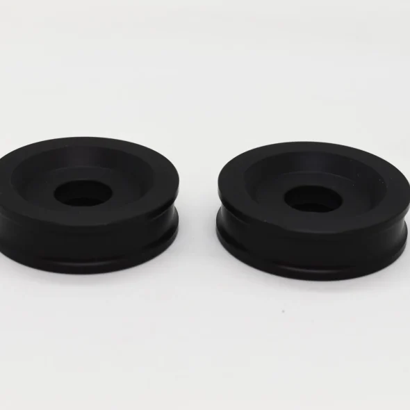 Two black round rubber grommets on a white background.
