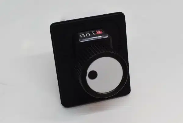 A black rotary dial switch with a white face on a light background.