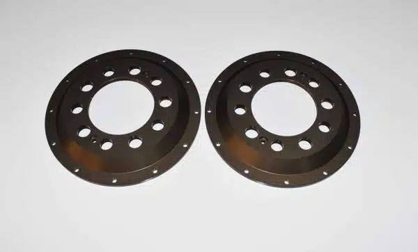 Two round metal plates with holes, placed side by side on a white background.