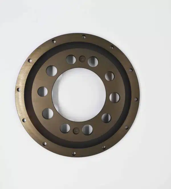A round metal gear with multiple holes, viewed from above on a white background.