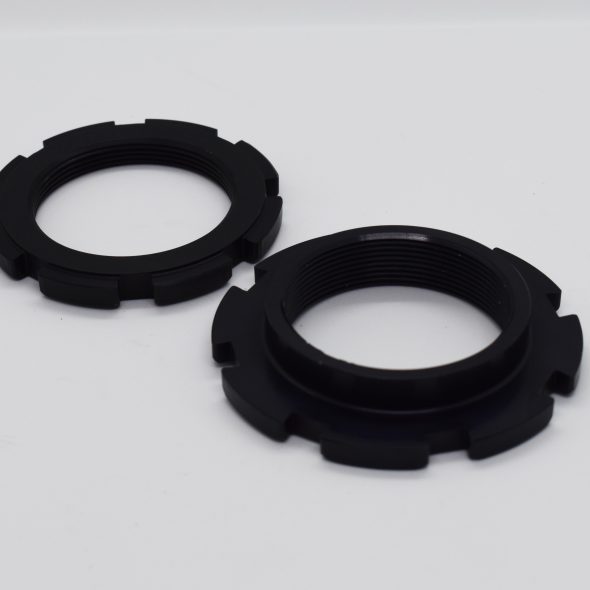 Two black circular lock rings placed on a white surface.