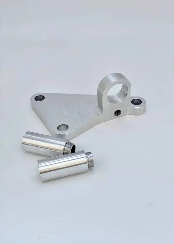 Silver metal bracket with two cylindrical metal pieces on a plain background.