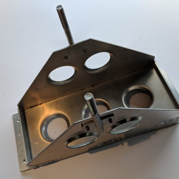 A metal frame with circular cutouts and two vertical rods on a white background.