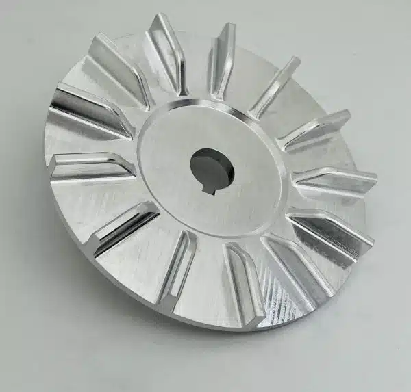 A shiny metal impeller with angled blades and a central hole is shown on a white background.