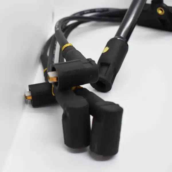 Black ignition leads for a car, shown with connectors, coiled on a white background.