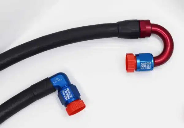 Two black oil cooler hoses with blue and red metal fittings on a white background.